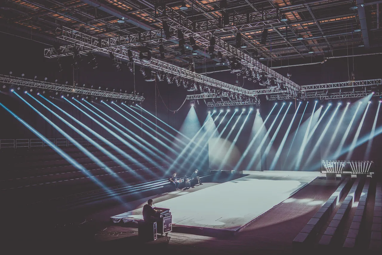 Event stage under a lighting rig with beams cutting across the room before the show